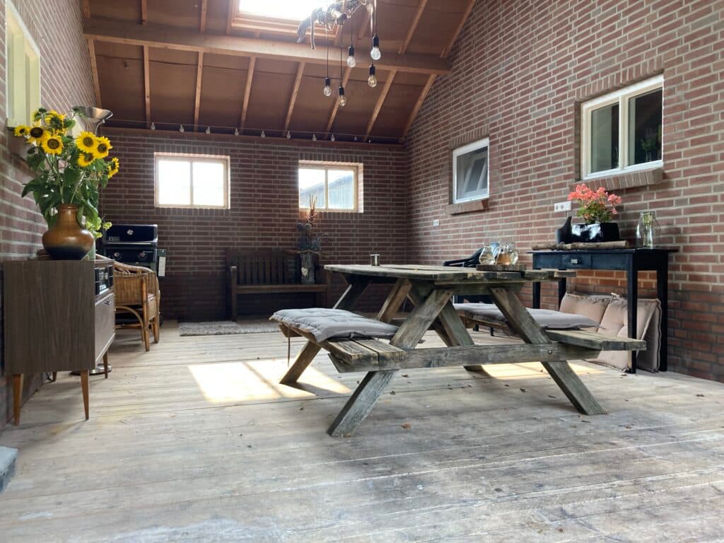 Covered indoor space with picnic table, atmospheric lighting and sunflowers