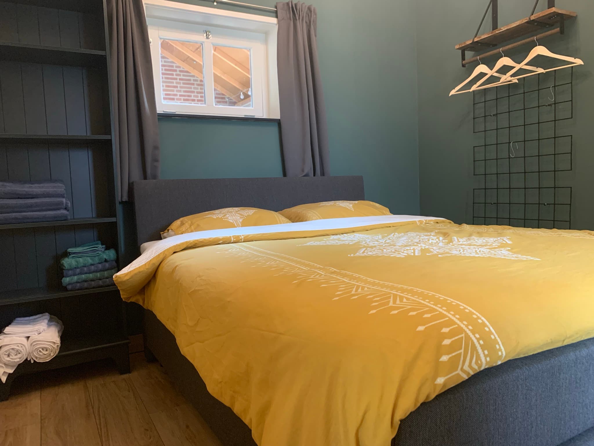 Bedroom with double bed and mustard yellow bedding